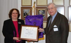 Dr. Curtis presents a framed certificate to  Mr. Rea